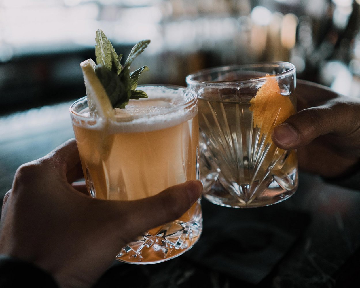 Zwei Personen stoßen mit ihren Cocktails an
