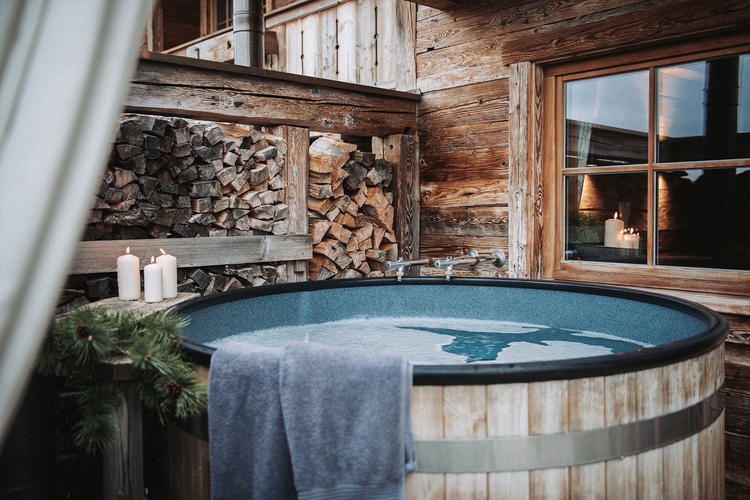 Aufnahme des Hot Pots auf der Chaletterrasse. Gemütlich mit Kerzen rundum und mit Wasser befüllt