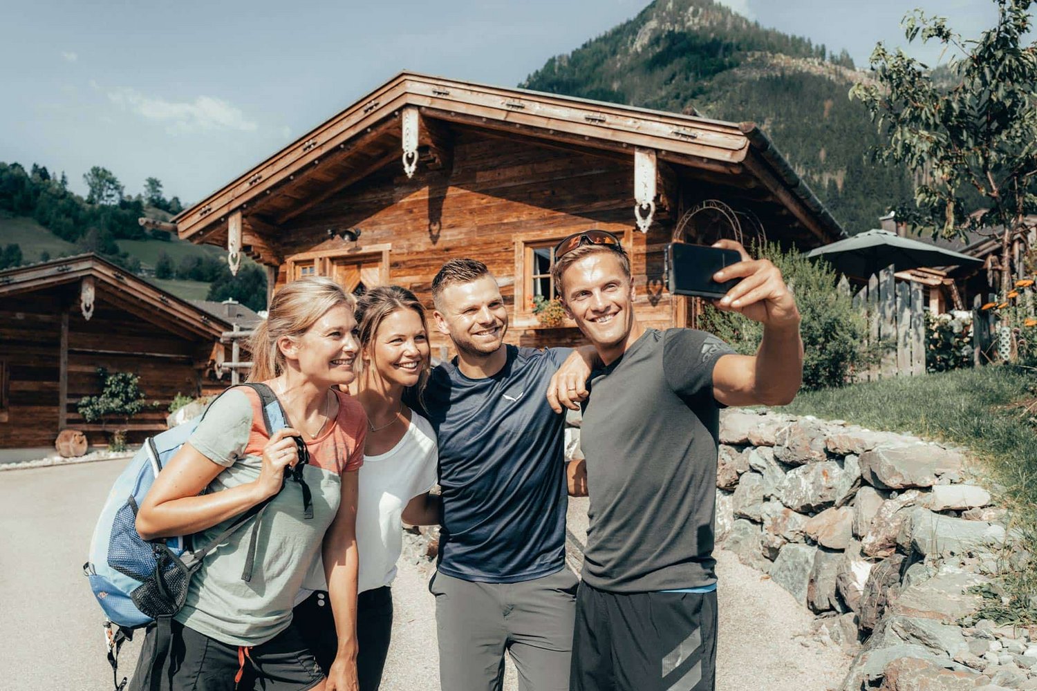 Sommerliche Aufnahme des Chaletdorfs mit Personen vor einem Chalet