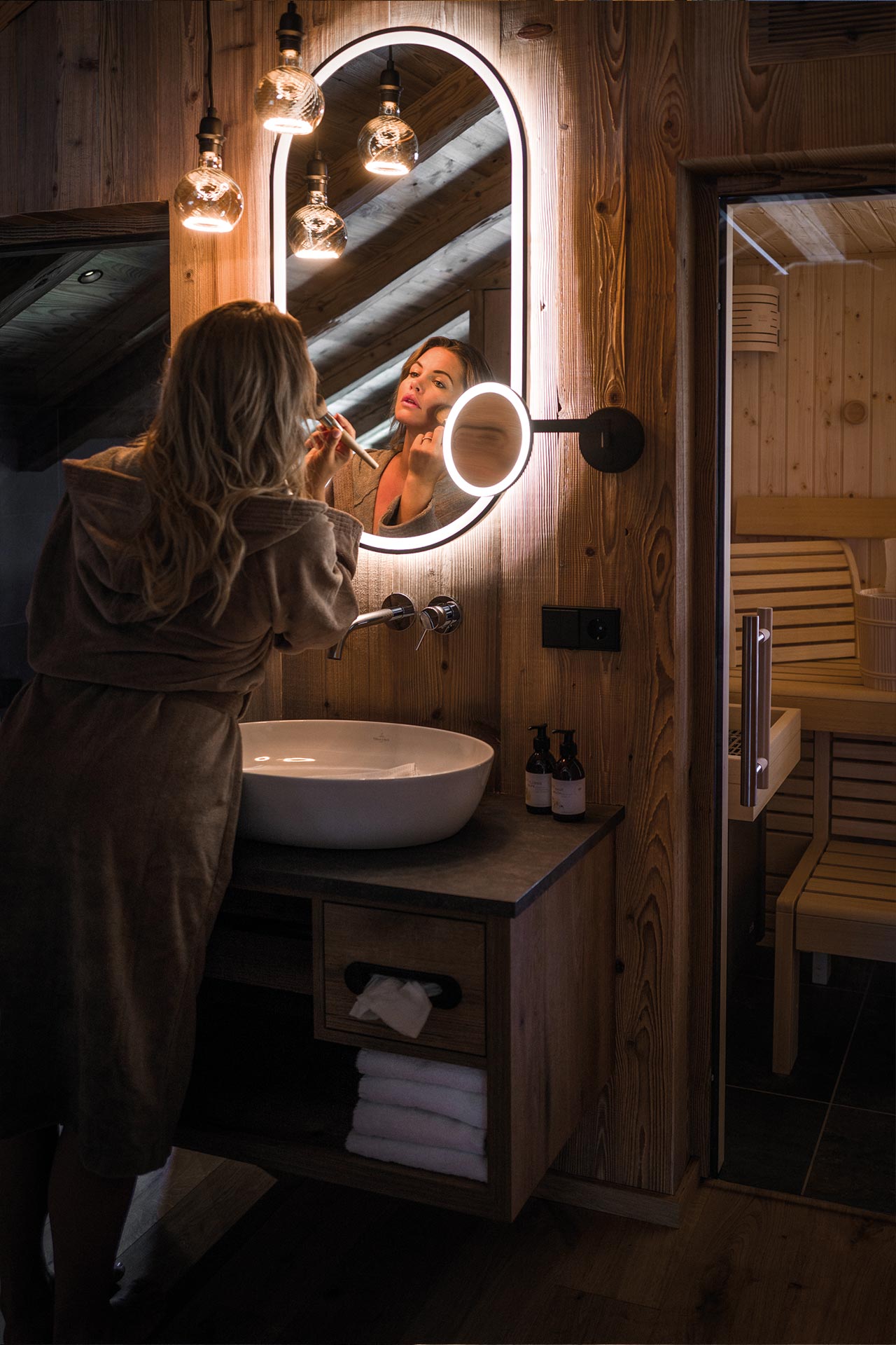 Detailaufnahme von Waschtisch mit Frau, Spiegel und Kosmetikspiegel