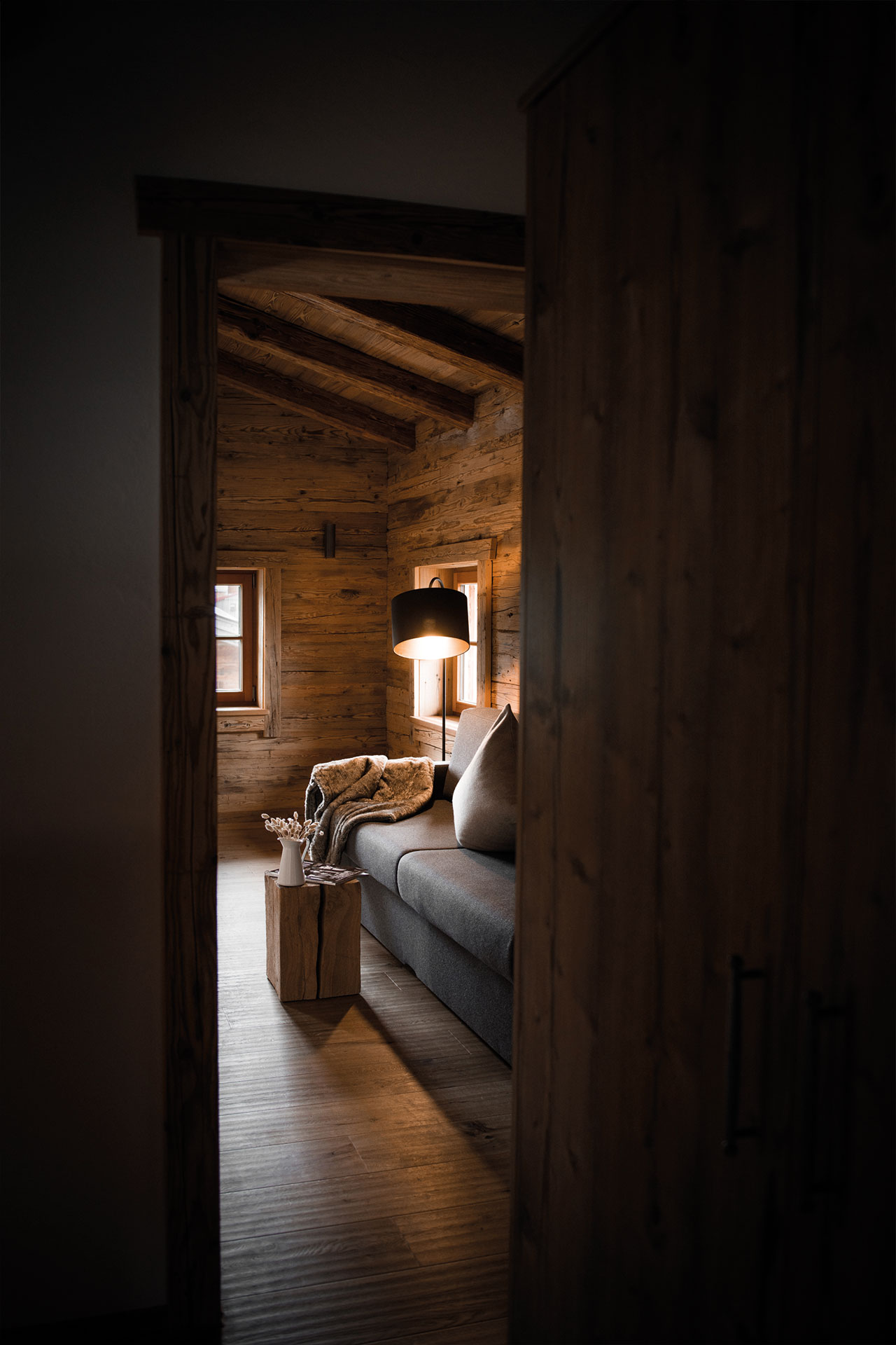Einblick in das Wohnzimmer des Chalets mit gemütlicher Leuchte