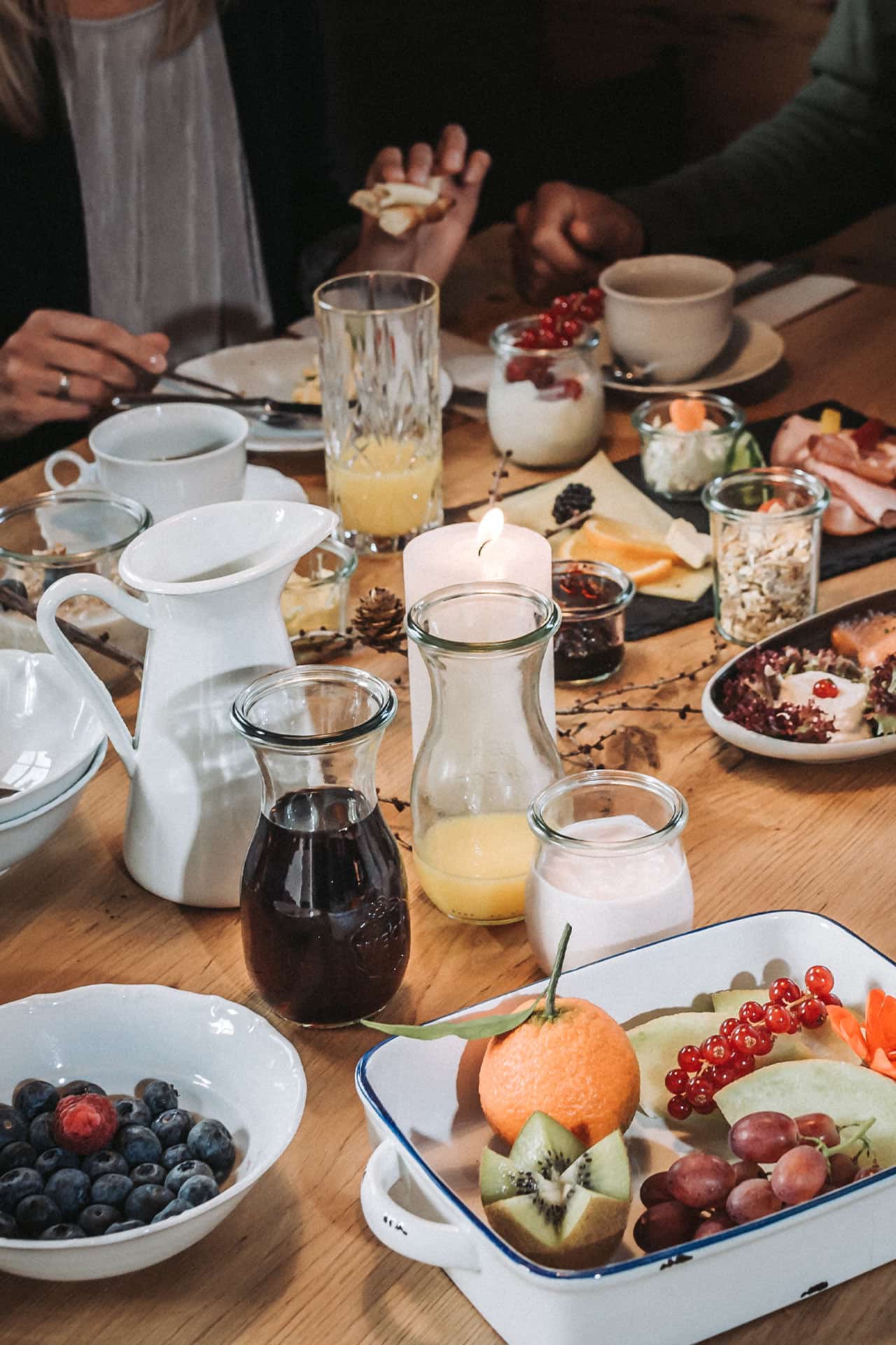 gedeckter Frühstückstisch mit Obst, Säften, Wurst und Käse in einem Chalet