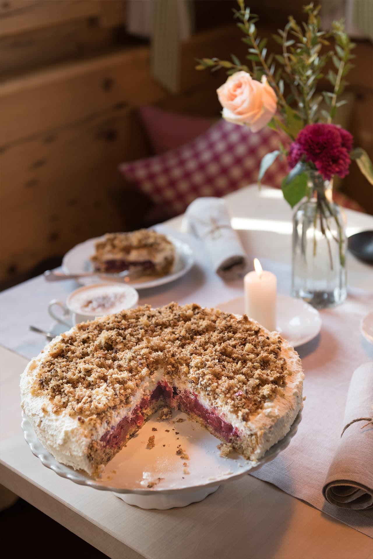 Aufnahme eines frisch gebackenes Kirsch-Streusel Kuchens auf einem eingedeckten Tisch