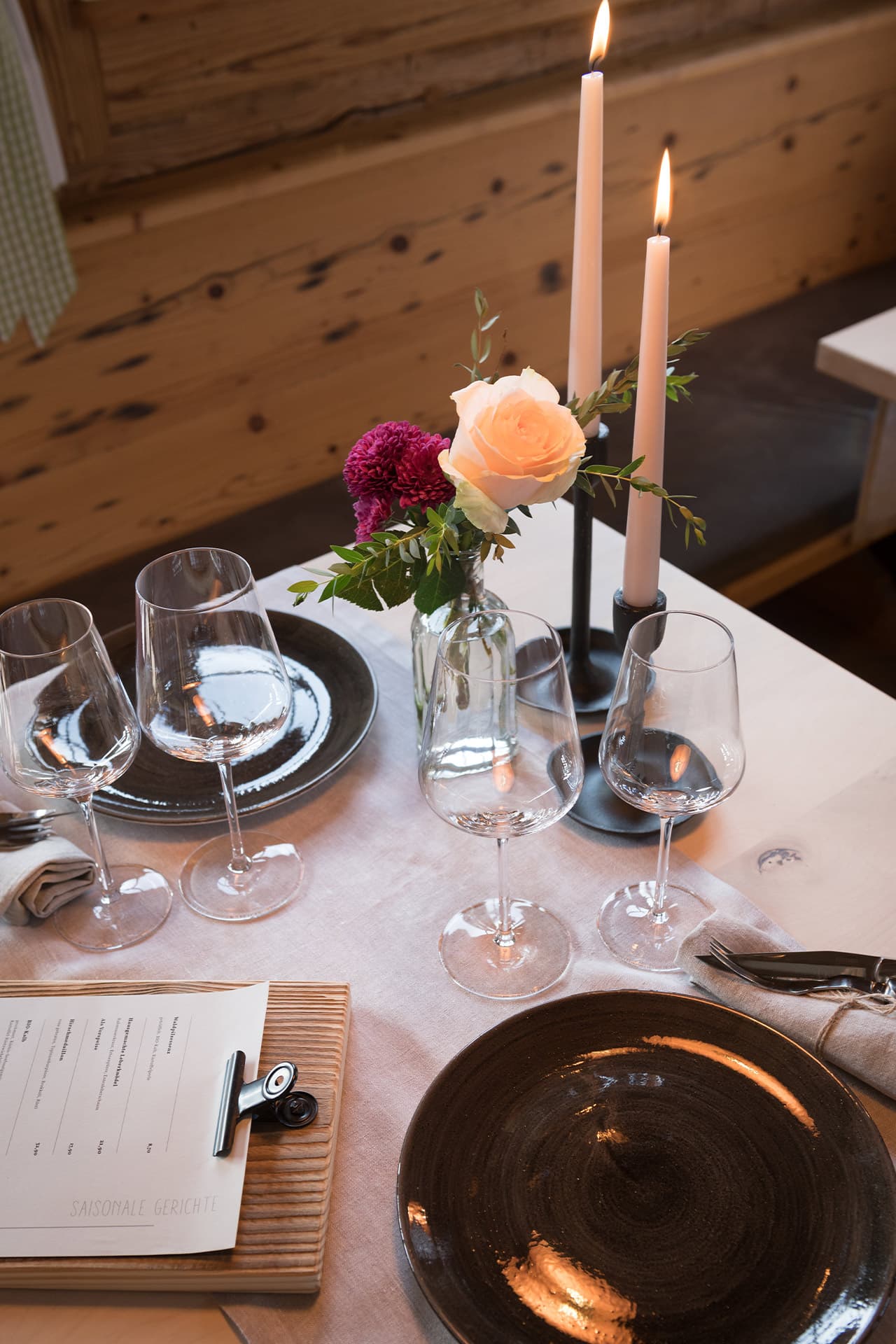 Aufnahme eines eingedeckten Tisches mit Kerzen, Blumen und diversen Gläsern für das Abendessen in Alpzitts Genusswerk