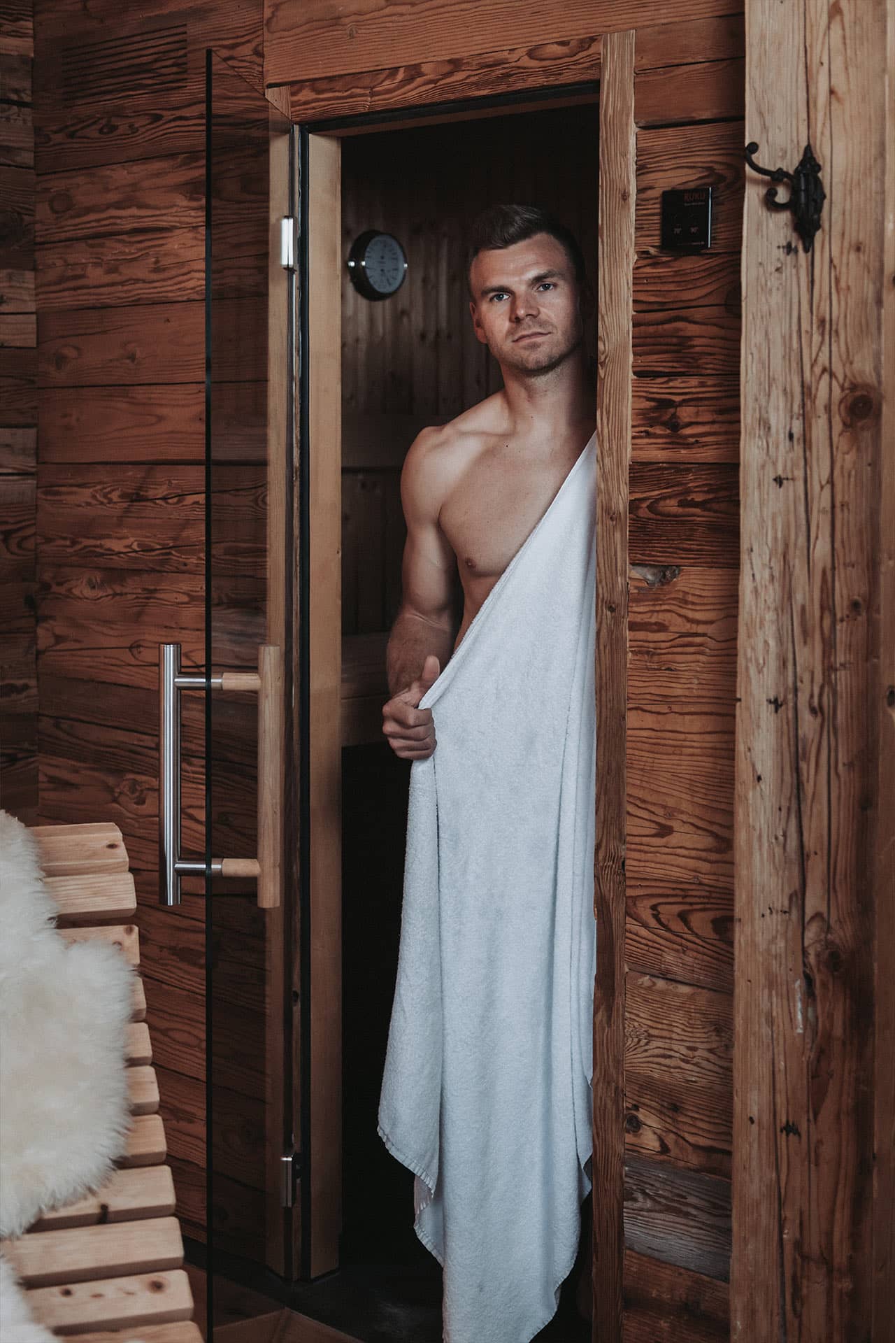 Ein Mann kommt gerade aus der Chaleteigenen Sauna und blickt in die Kamera
