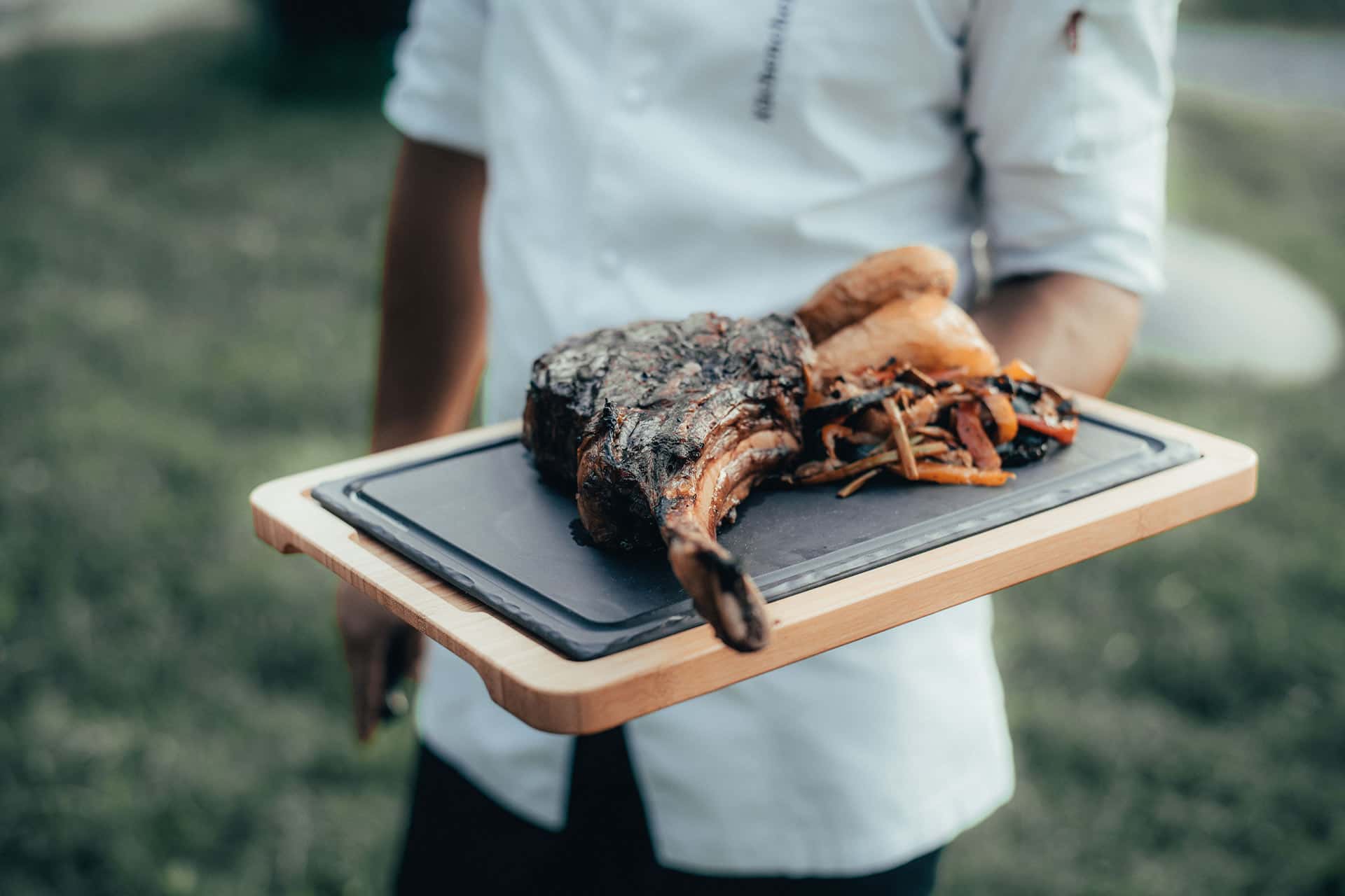 Küchenchef Alex serviert eine hochwertige Fleischspeise in Alpzitts Garten