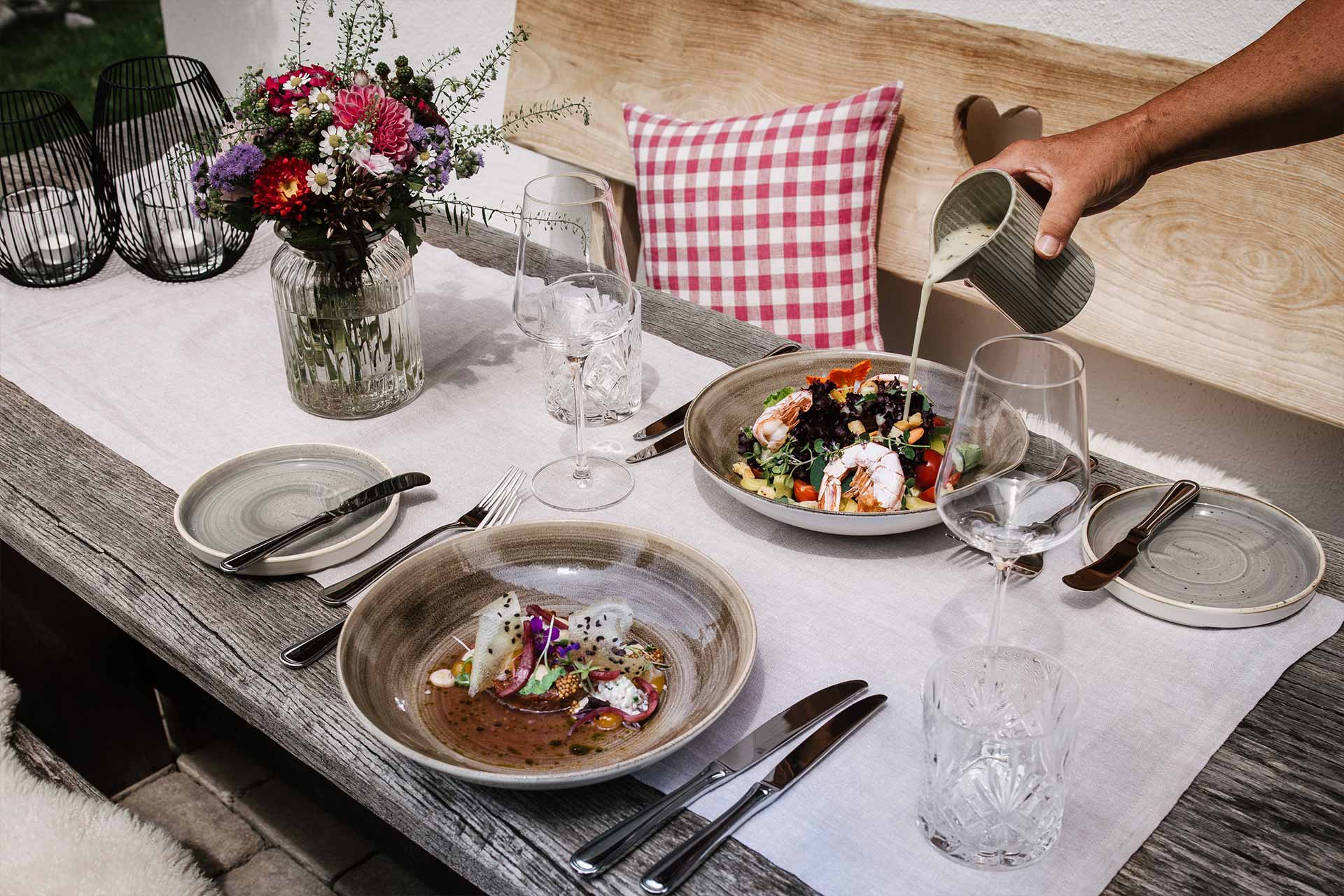 Aufnahme feiner Speisen, serviert auf der eigenen Chaletterrasse