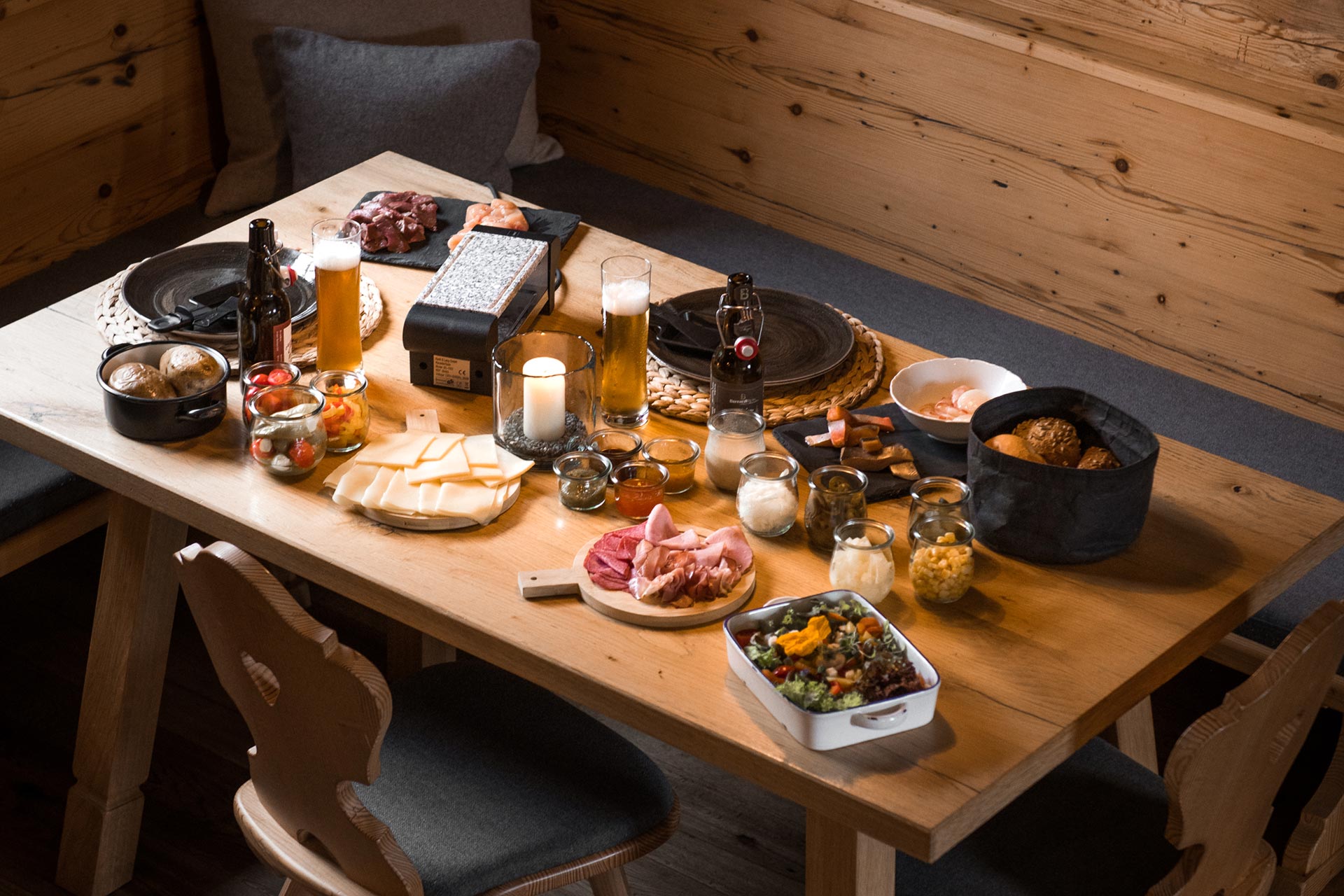 Aufnahme eines üppig gedeckten Tisches für ein Raclette Dinner im eigenen Chalet