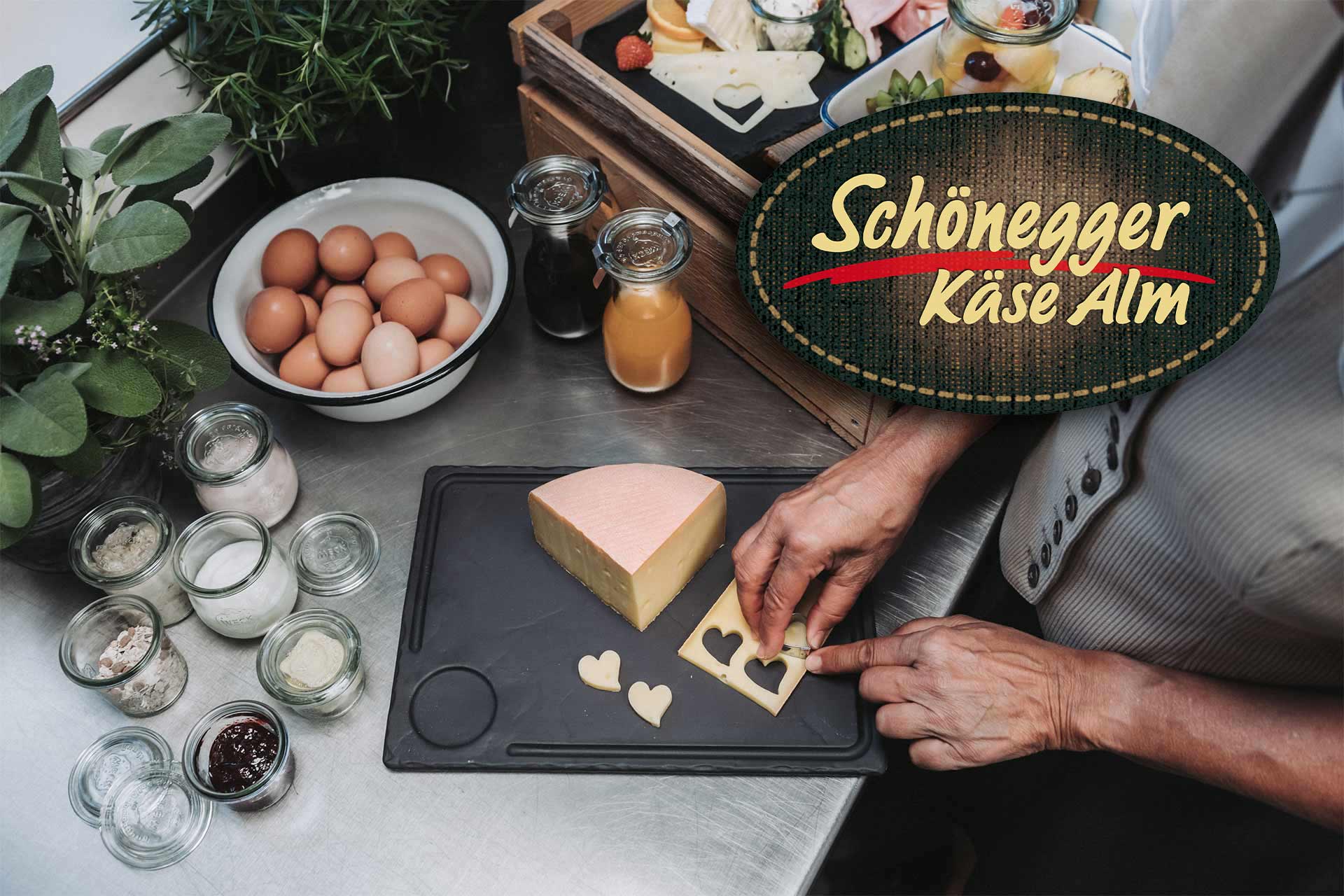 Bild einer Dame beim Herrichten des Frühstücks. Im rechten oberen Eck steht das Schönegger Käsealm Logo